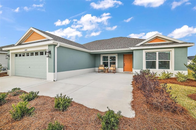 ranch-style house with a garage, concrete driveway, a shingled roof, and stucco siding