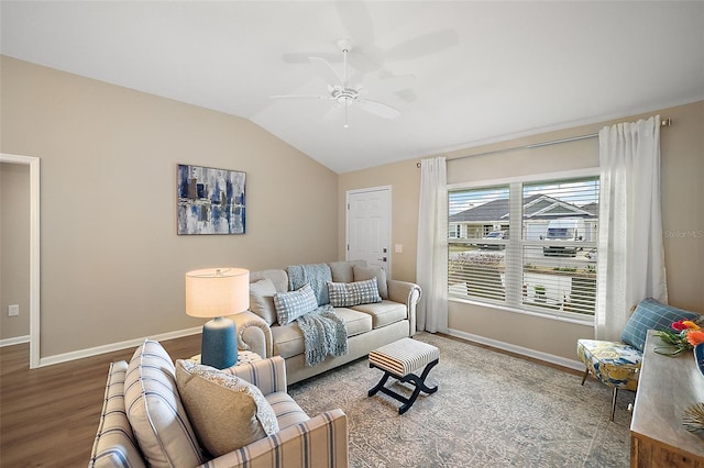 living area with a ceiling fan, baseboards, vaulted ceiling, and wood finished floors