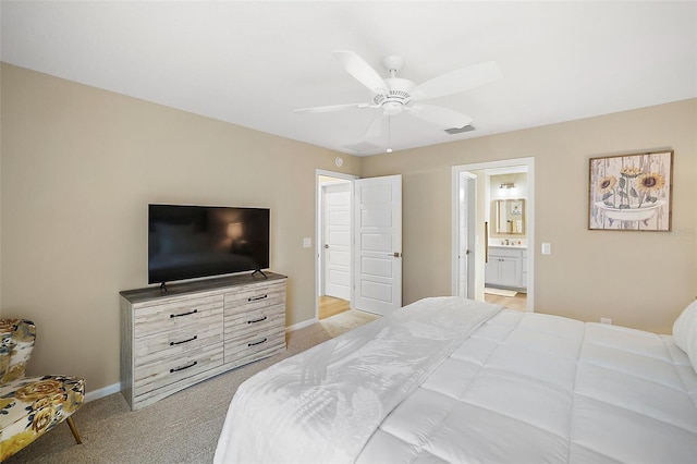 bedroom with baseboards, visible vents, a ceiling fan, light colored carpet, and ensuite bathroom