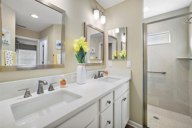 bathroom featuring double vanity, a sink, visible vents, and a shower stall