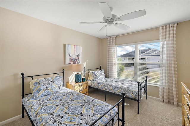 bedroom featuring light carpet, ceiling fan, and baseboards