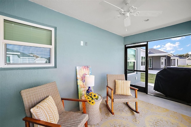 living area with ceiling fan and finished concrete flooring