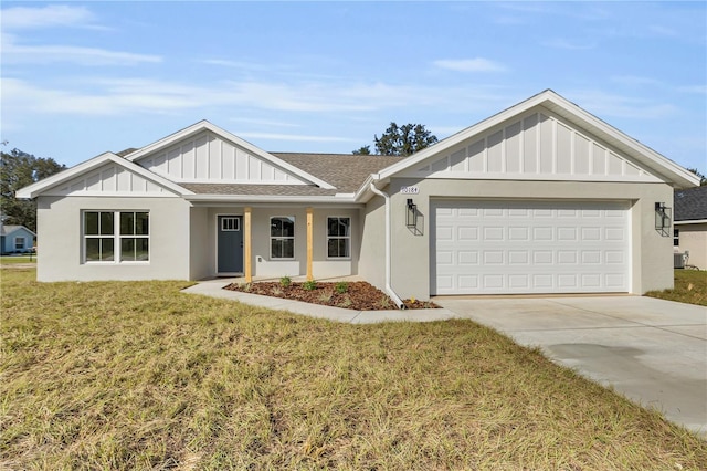 view of front facade featuring a garage, a shingled roof, concrete driveway, board and batten siding, and a front yard