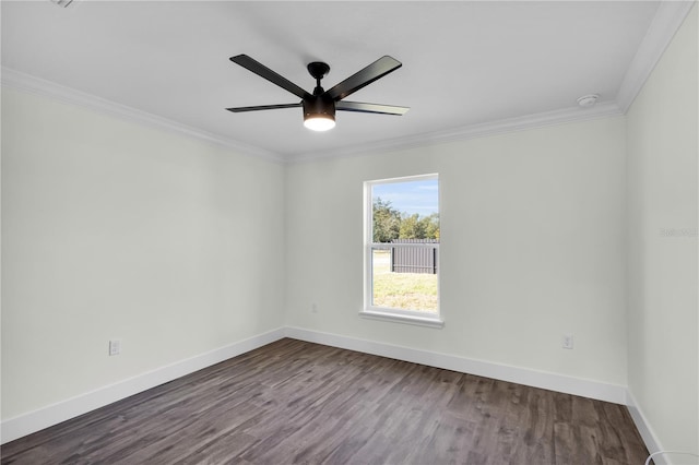 spare room with ornamental molding, dark wood finished floors, and baseboards