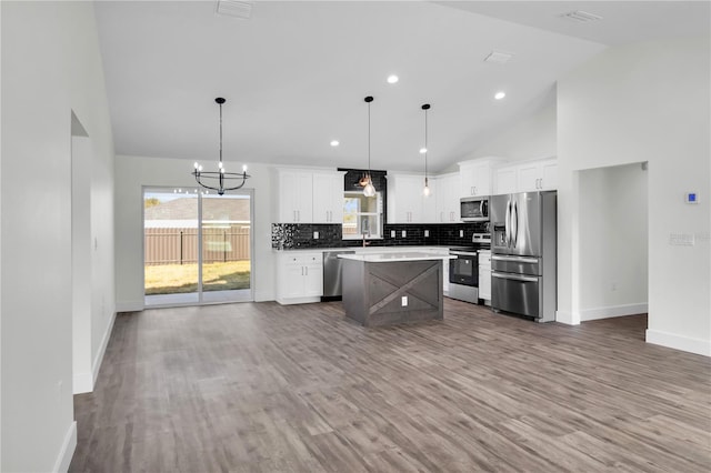 kitchen featuring stainless steel appliances, plenty of natural light, backsplash, and white cabinets