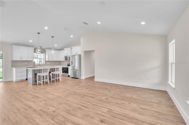13334 SW 107th St, Dunnellon, FL 34432 - kitchen with stainless steel appliances, light countertops, white cabinets, backsplash, and a kitchen bar