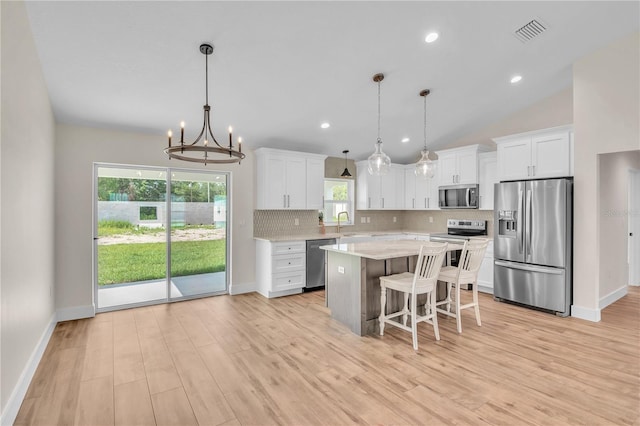 13334 SW 107th St, Dunnellon, FL 34432 - kitchen with appliances with stainless steel finishes, light countertops, decorative backsplash, white cabinets, and a chandelier