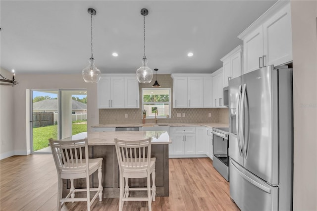 13334 SW 107th St, Dunnellon, FL 34432 - kitchen featuring stainless steel appliances, white cabinets, a center island, decorative backsplash, and recessed lighting