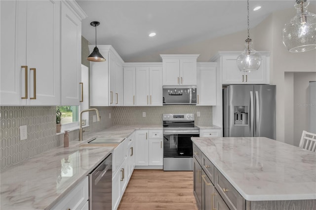 13334 SW 107th St, Dunnellon, FL 34432 - kitchen featuring stainless steel appliances, light wood-type flooring, white cabinetry, vaulted ceiling, and backsplash