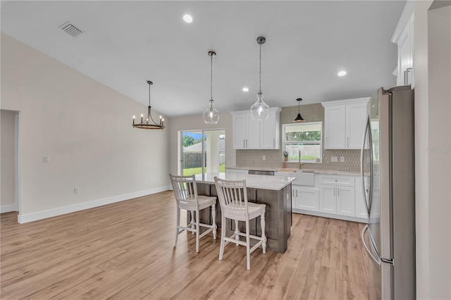 13334 SW 107th St, Dunnellon, FL 34432 - kitchen with freestanding refrigerator, decorative backsplash, white cabinetry, light wood-style flooring, and recessed lighting