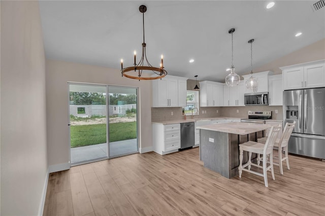 13334 SW 107th St, Dunnellon, FL 34432 - kitchen with stainless steel appliances, tasteful backsplash, a chandelier, a center island, and white cabinets