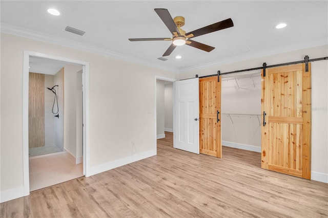 13334 SW 107th St, Dunnellon, FL 34432 - unfurnished bedroom with a barn door, wood finished floors, recessed lighting, ornamental molding, and ensuite bathroom