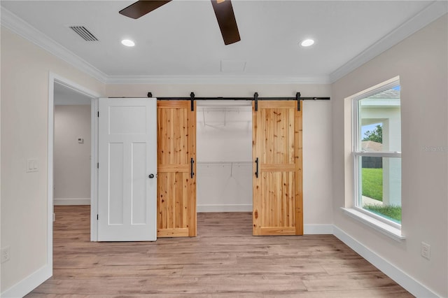 13334 SW 107th St, Dunnellon, FL 34432 - unfurnished bedroom with ornamental molding, light wood-type flooring, a barn door, recessed lighting, and ceiling fan