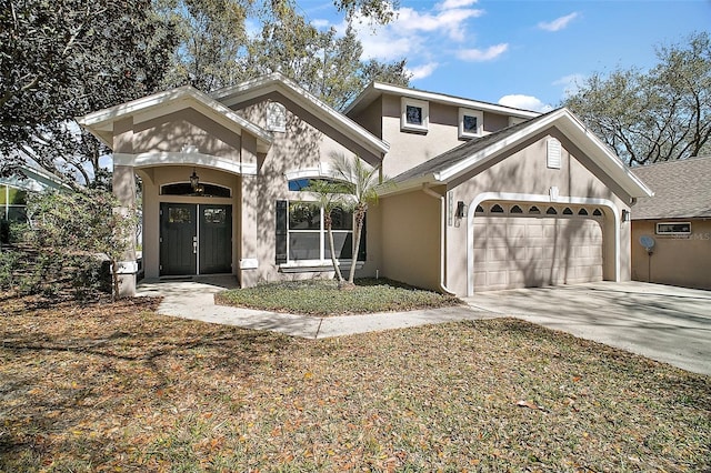 view of front of property featuring a garage, driveway, and stucco siding