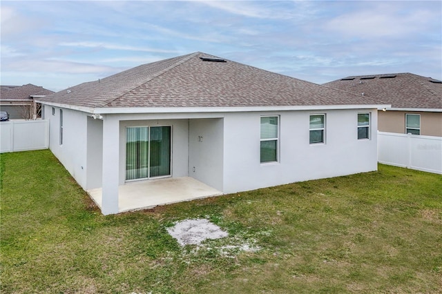 back of property with a fenced backyard, a patio area, a lawn, and roof with shingles