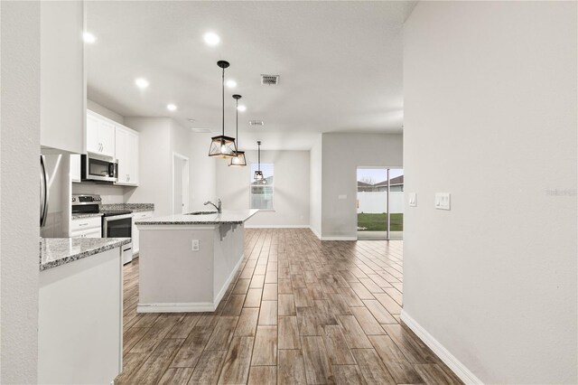 kitchen with visible vents, light wood-type flooring, a sink, white cabinetry, and appliances with stainless steel finishes