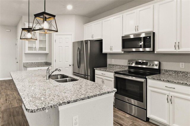 kitchen featuring dark wood-type flooring, light stone counters, appliances with stainless steel finishes, white cabinets, and a sink