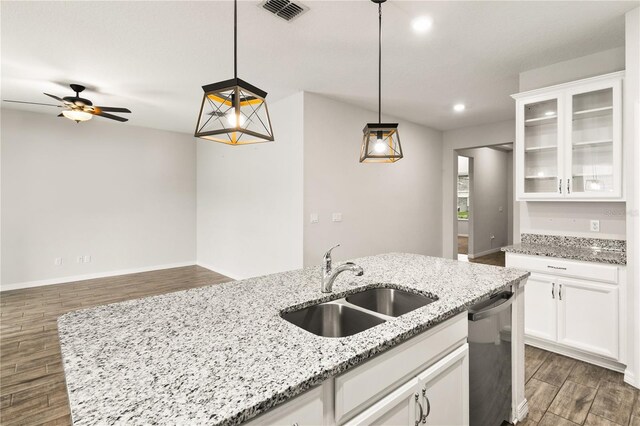 kitchen with visible vents, dark wood-style flooring, stainless steel dishwasher, white cabinetry, and a sink