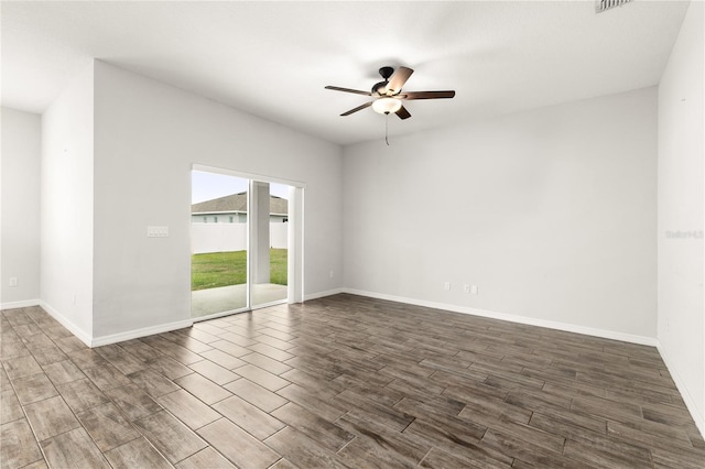 empty room featuring baseboards, dark wood-style floors, and a ceiling fan