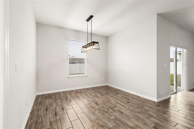 unfurnished dining area featuring baseboards and wood finished floors