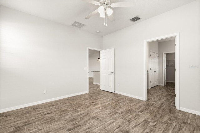 unfurnished bedroom with visible vents, baseboards, and wood finished floors