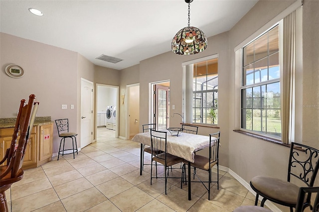 dining area with visible vents, washer and clothes dryer, baseboards, and light tile patterned flooring