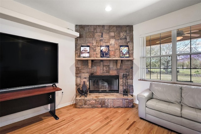 living room with a fireplace, wood finished floors, and baseboards