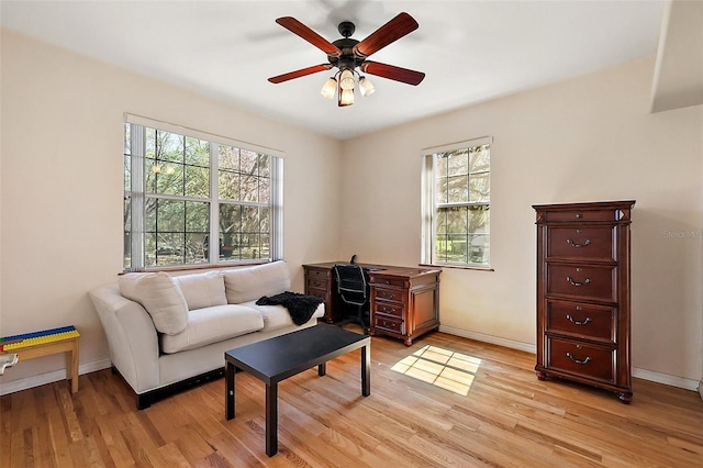 interior space with light wood-style flooring, baseboards, and a ceiling fan