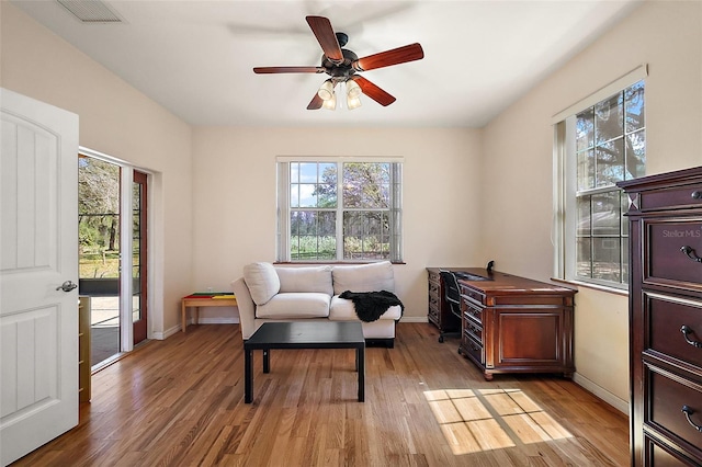 sitting room featuring ceiling fan, light wood finished floors, visible vents, and baseboards