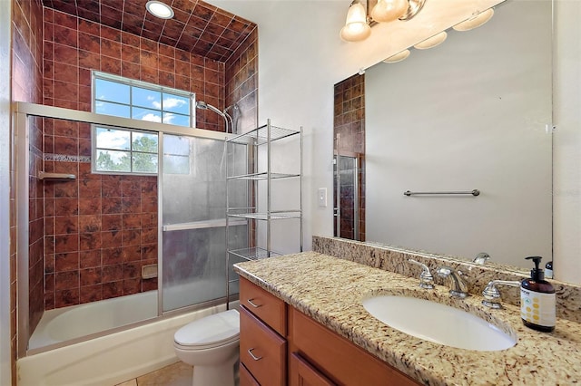 full bath with enclosed tub / shower combo, vanity, and toilet