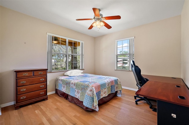 bedroom with light wood-type flooring, ceiling fan, and baseboards