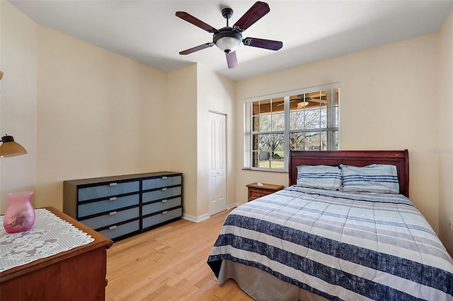 bedroom with a ceiling fan, a closet, baseboards, and wood finished floors