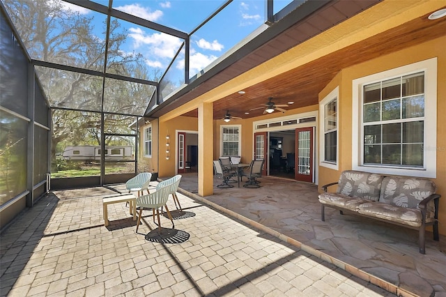 unfurnished sunroom with ceiling fan