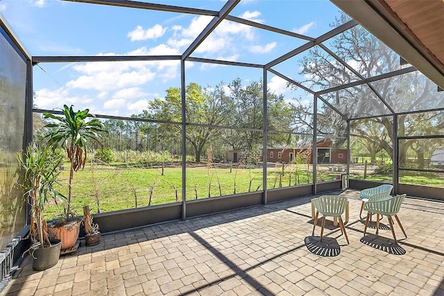 view of patio / terrace featuring glass enclosure and an outdoor structure