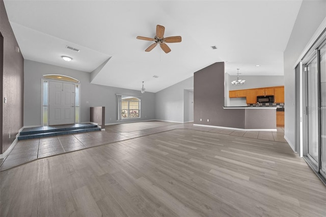 unfurnished living room featuring light wood-type flooring, visible vents, baseboards, and lofted ceiling