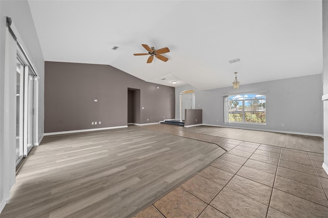 unfurnished living room featuring light wood-type flooring, visible vents, ceiling fan, and vaulted ceiling