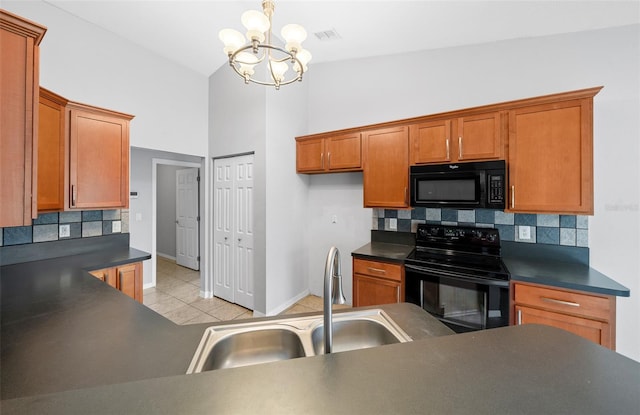 kitchen with dark countertops, black appliances, and a sink