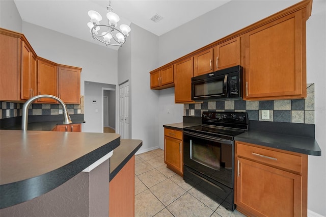 kitchen featuring visible vents, black appliances, dark countertops, brown cabinets, and backsplash