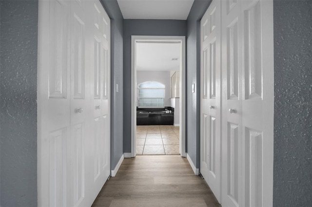 hallway featuring baseboards and wood finished floors