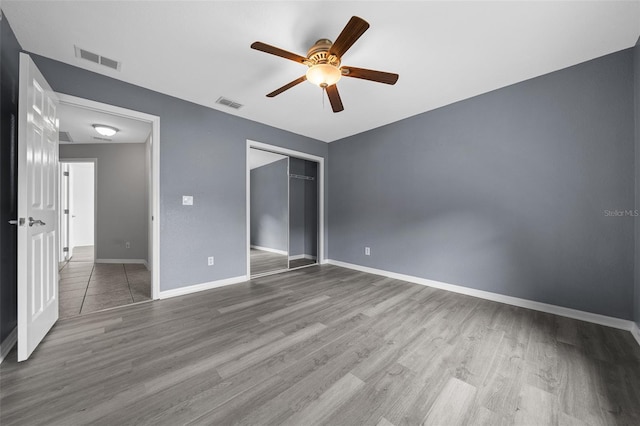 unfurnished bedroom with visible vents, baseboards, and wood finished floors