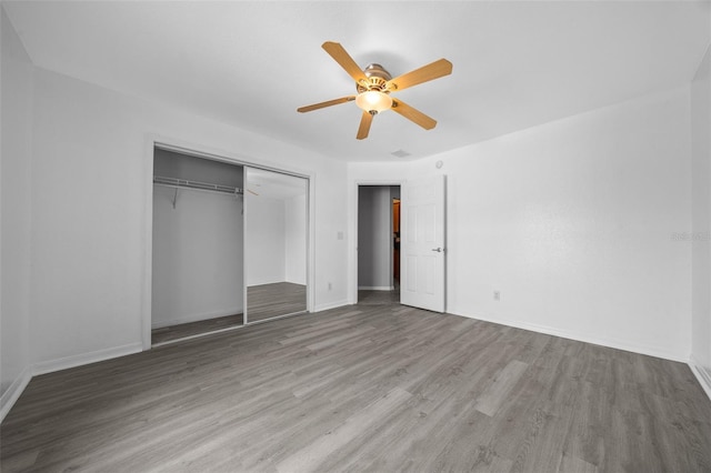unfurnished bedroom with ceiling fan, a closet, baseboards, and wood finished floors