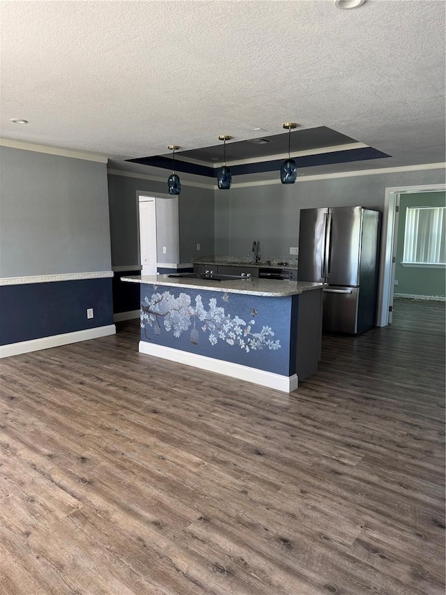 kitchen featuring dark wood-style floors, a large island, a raised ceiling, and freestanding refrigerator