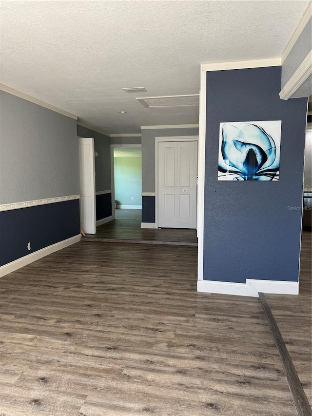 spare room featuring a textured ceiling, baseboards, and wood finished floors