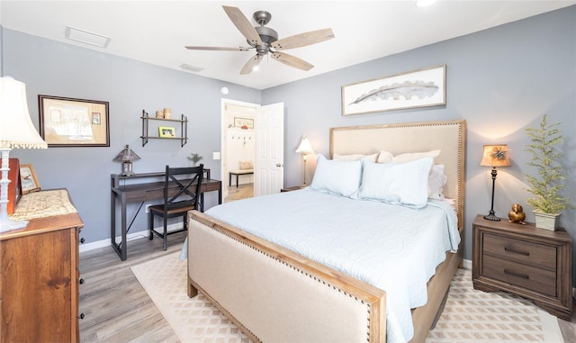 bedroom featuring baseboards, a ceiling fan, visible vents, and light wood-style floors