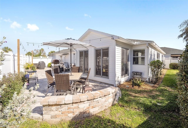 rear view of house featuring a fenced backyard and a patio