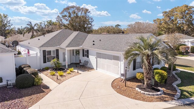 ranch-style house featuring a garage, a shingled roof, fence, and concrete driveway