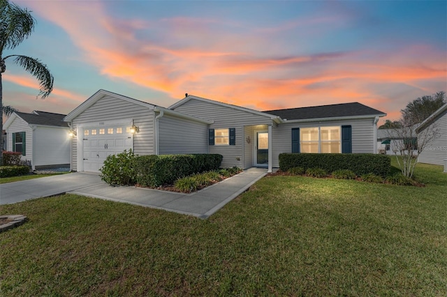 ranch-style home with an attached garage, concrete driveway, and a yard