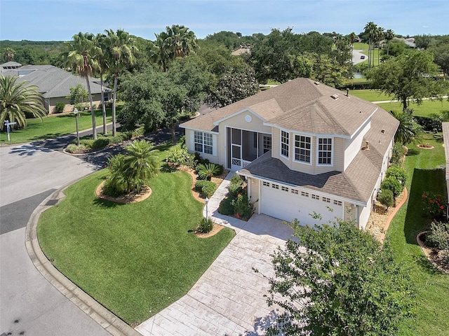 view of front facade featuring driveway, a garage, a front lawn, and roof with shingles