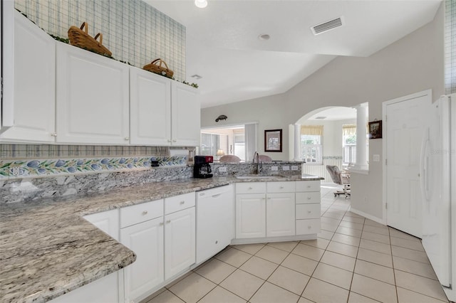 kitchen featuring arched walkways, light tile patterned floors, visible vents, a sink, and white appliances