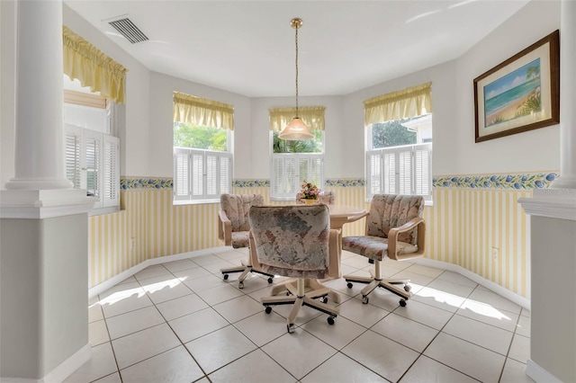 dining area with a healthy amount of sunlight, light tile patterned flooring, visible vents, and wainscoting